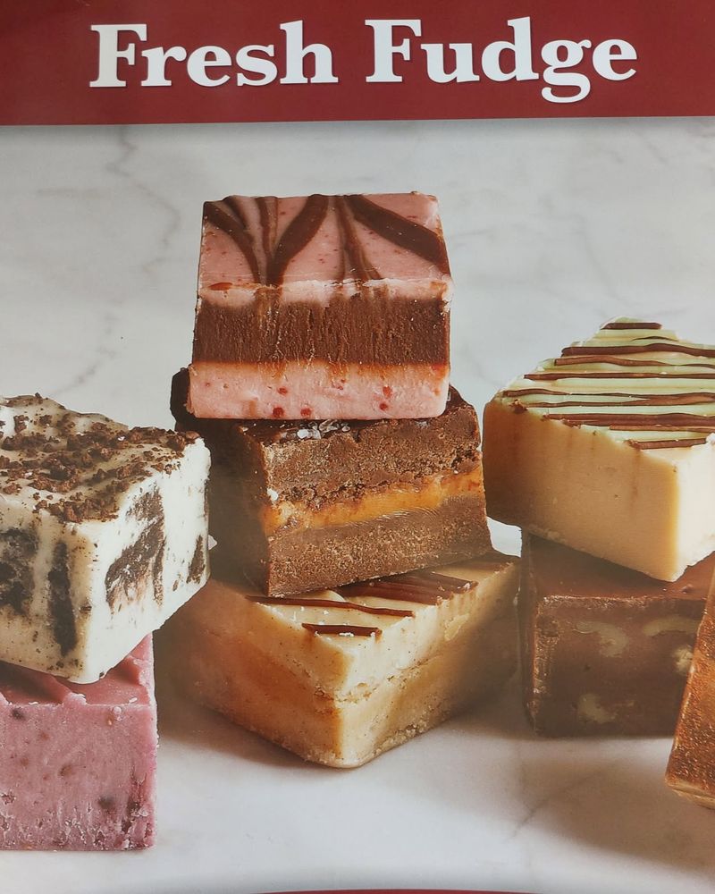 Slabs of fudge stacked under the Fresh Fudge sign