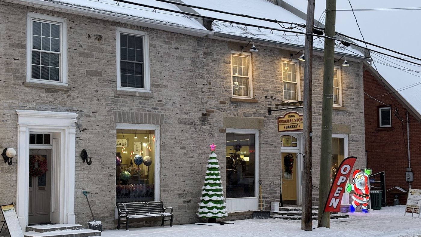The stone storefront in winter, a small Christmas tree by the door
